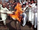Students of religious schools in Karachi beat a burning effigy of President Bush